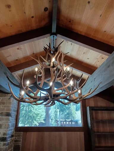 Rustic antler chandelier wired into a vaulted cabin ceiling